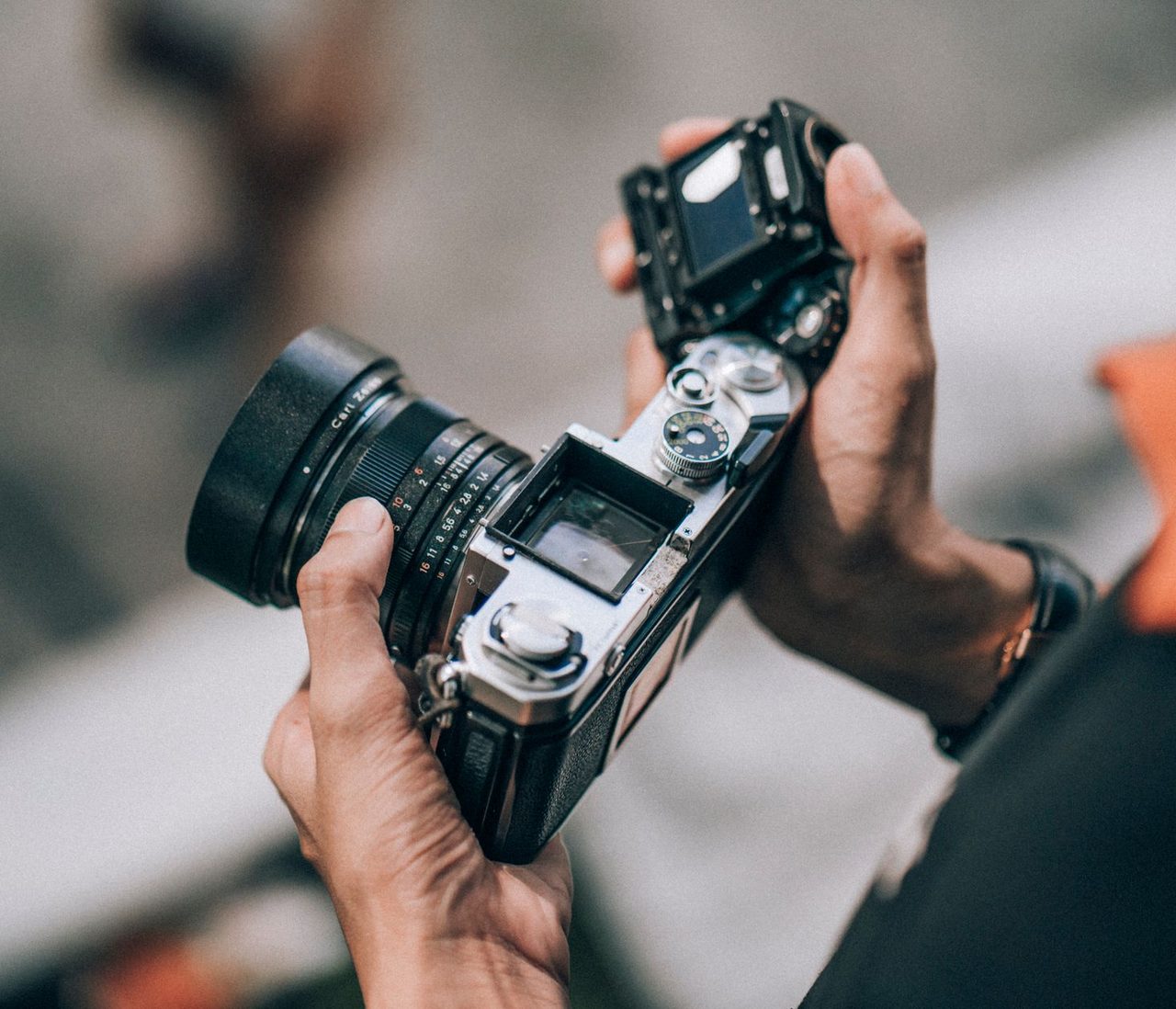 Hands holding a film camera with its back open